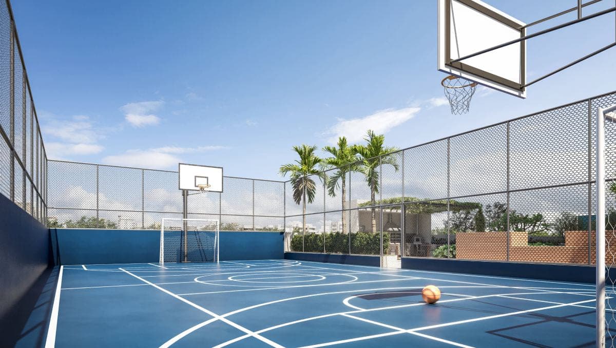 Quadra recreativa em piso azul, com tabela de basquete, gol e alambrado, no topo do prédio