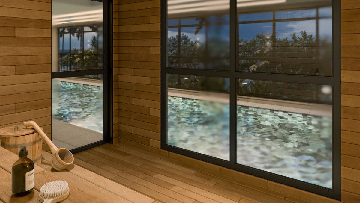Sauna seca revestida em madeira, com balde, escova e janelas para a piscina